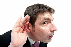 man holding out his ear